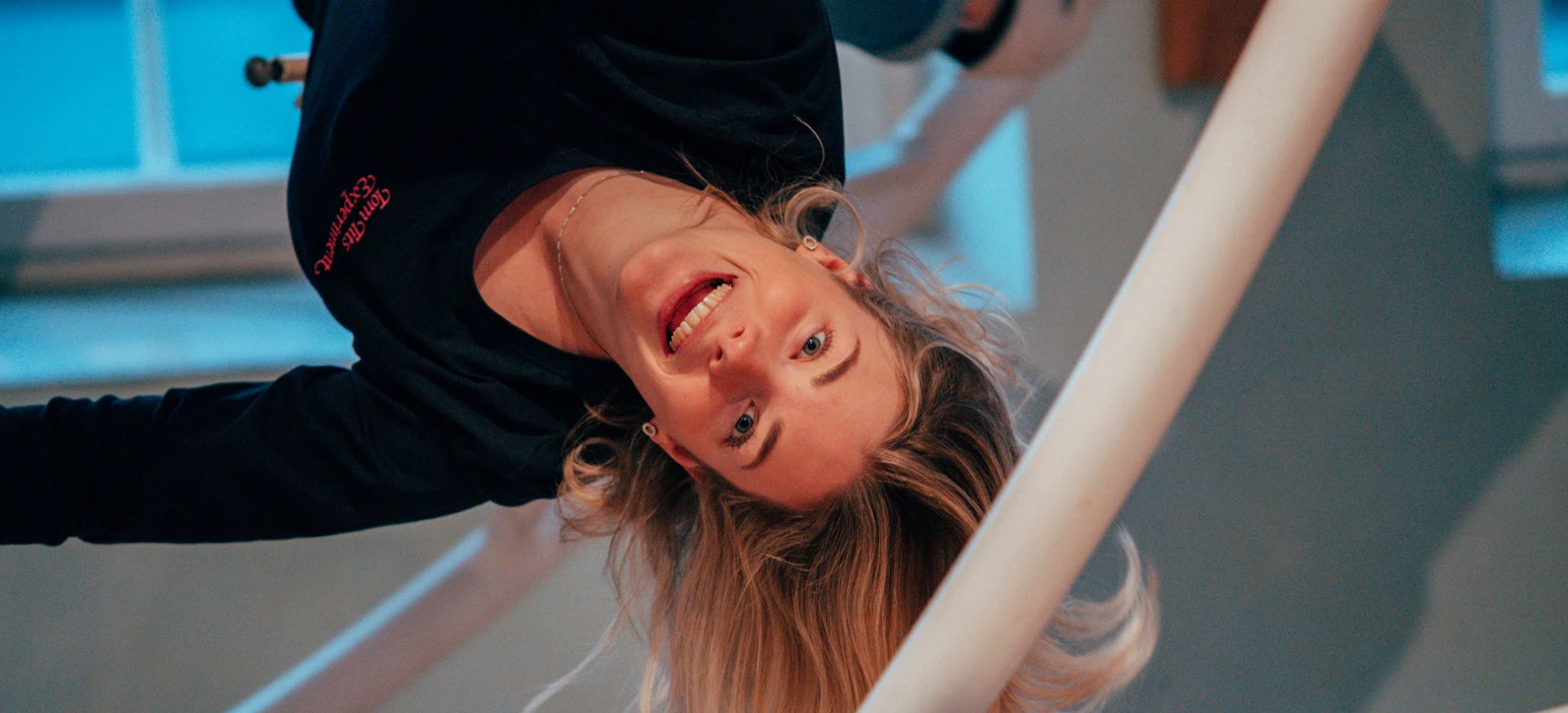 A girl is upside down i the ride space ball