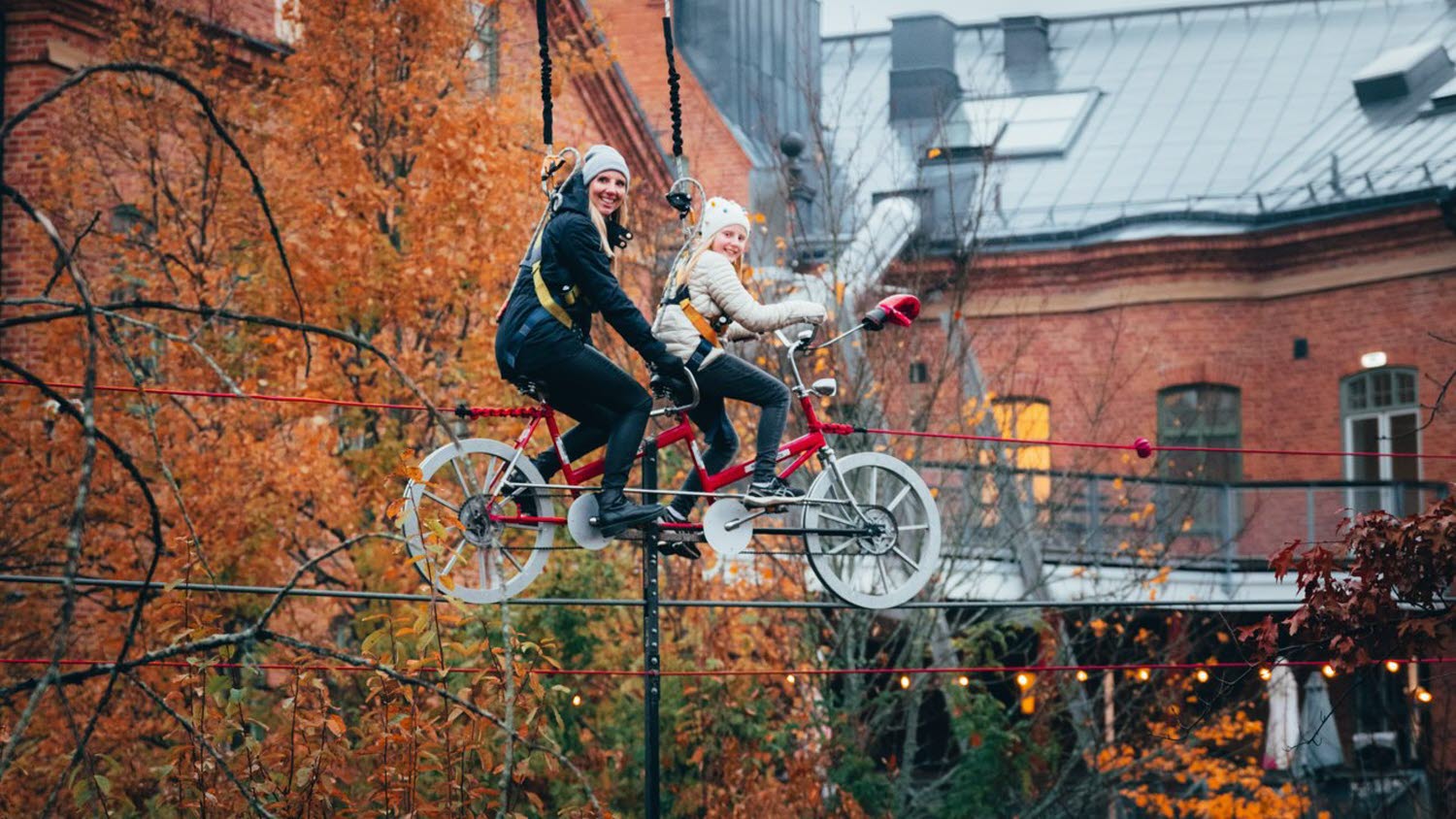 Förälder och barn cyklar på lina